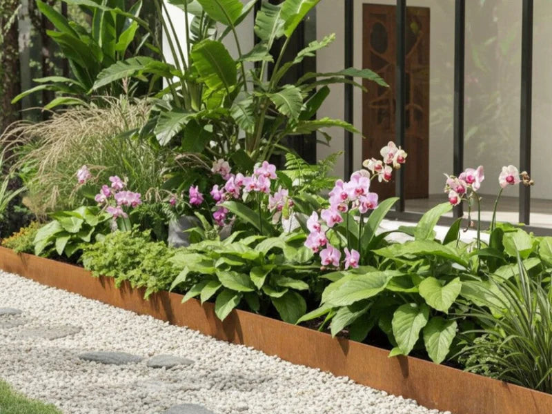 Bedkant i cortenstål med tropiske planter langs terrasse