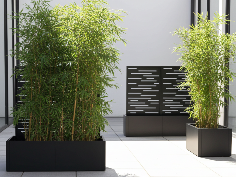 Sortlakkert plantekasse i stål med spalier, brukt som skjerming på terrasse.