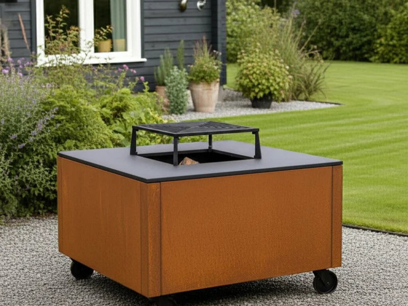 CUBY bålgrill i cortenstål i klassisk hage med gressplen og busker