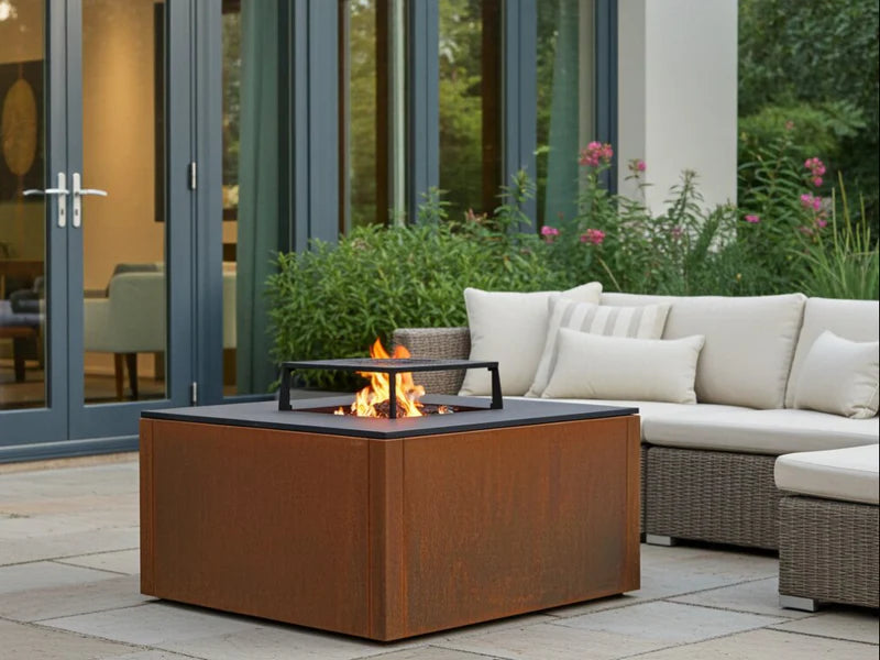 CUBY bålgrill i cortenstål på terrasse i loungeområde med synlige flammer