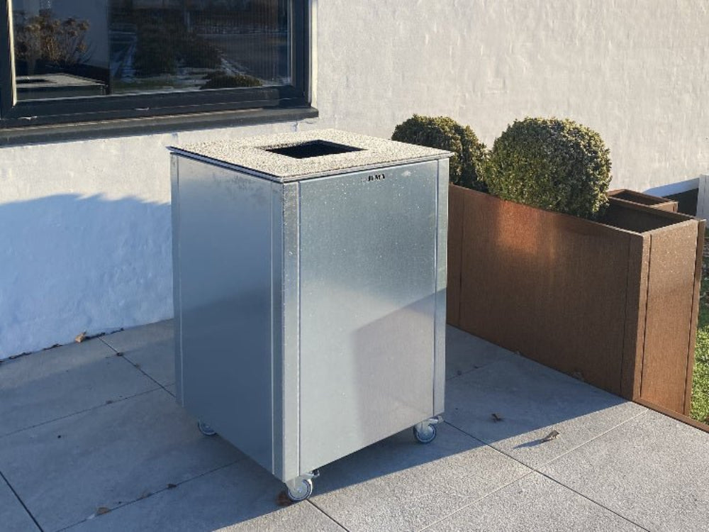 CUBY bålgrill i galvanisert stål plassert ved bolig i utendørs miljø