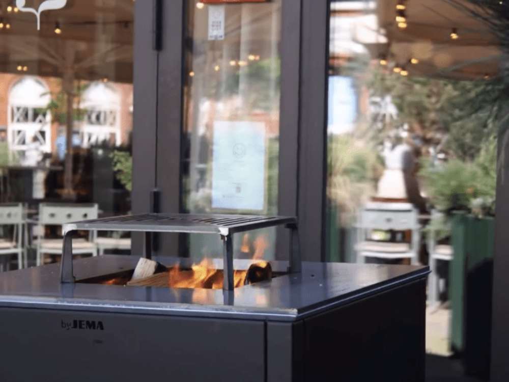 CUBY bålgrill i svartlakkert stål i utendørs restaurantmiljø