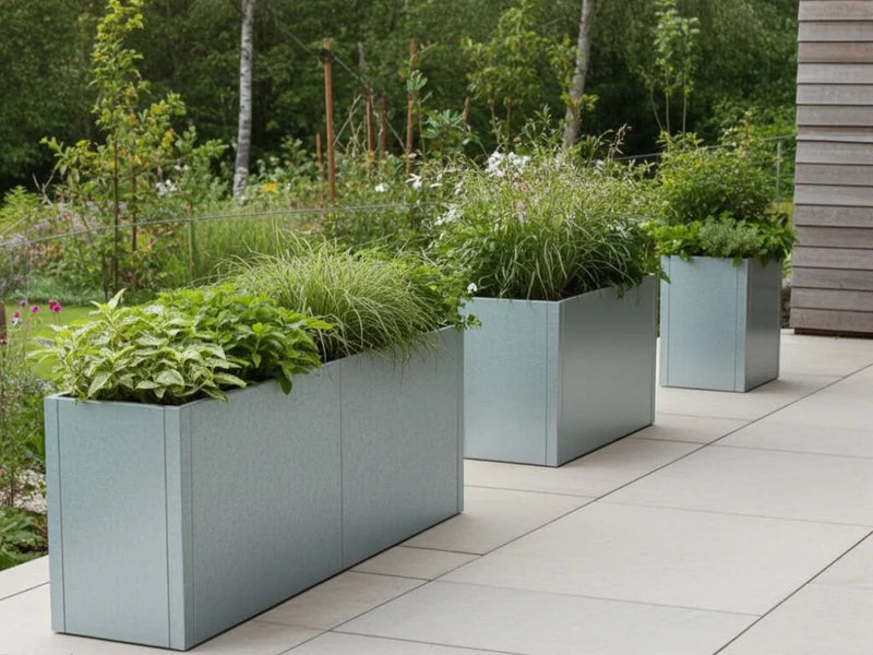 Plantekasser i galvanisert stål fra CUBY med stauder langs terrasse