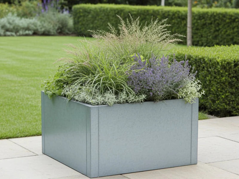CUBY kvadratisk plantekasse i galvanisert stål med prydgress i hage