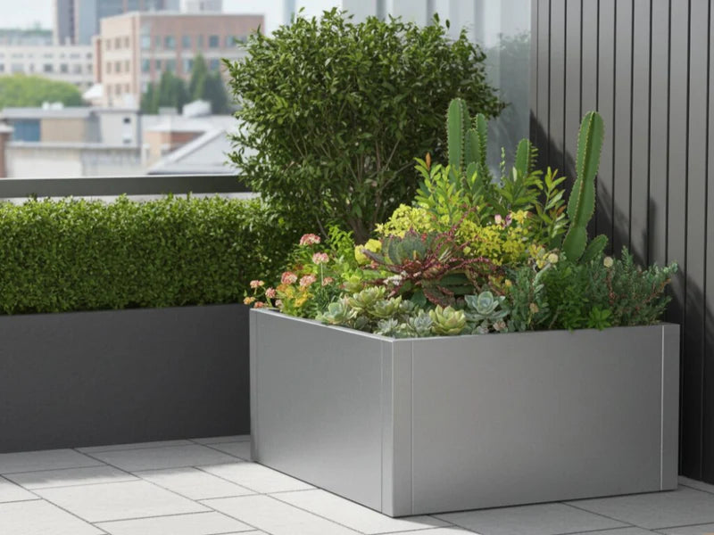 CUBY lav kvadratisk plantekasse i galvanisert stål med variert beplantning på urban terrasse