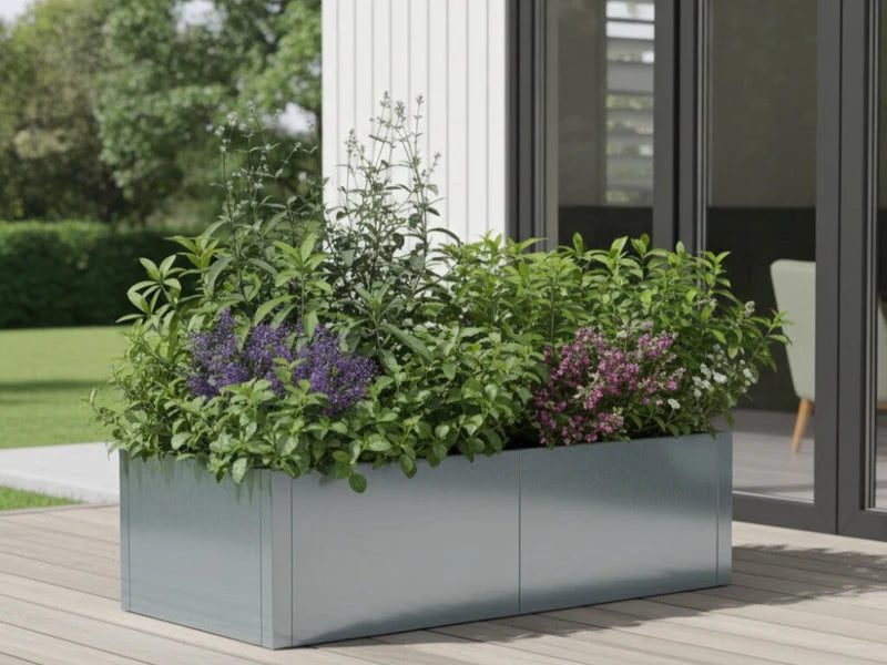 CUBY lav rektangulær plantekasse i galvanisert stål med blomstrende planter ved moderne fasade
