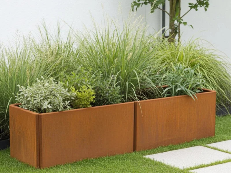 EDGY lav rektangulær plantekasse i cortenstål med prydgress i hage