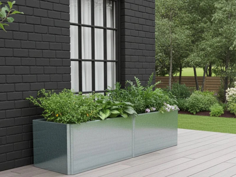 Lang EDGY plantekasse i galvanisert stål foran mørk murfasade