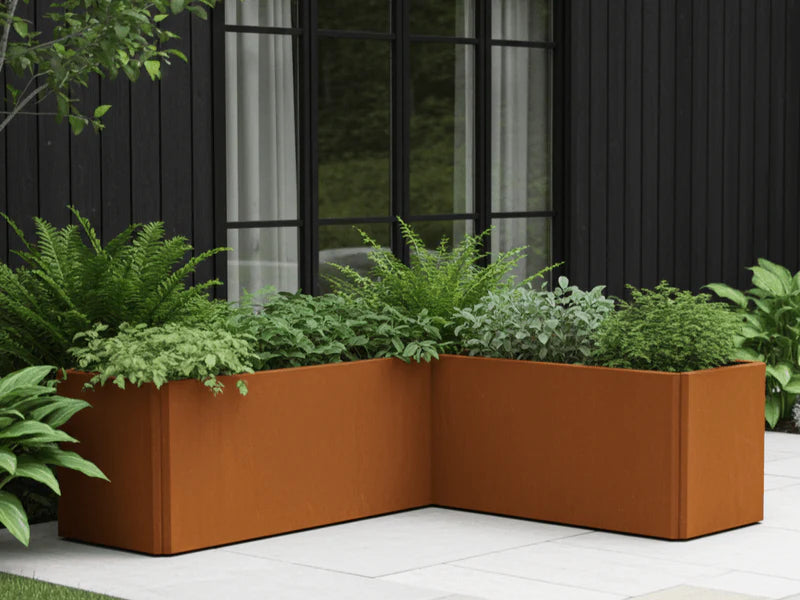 Vinkelformet EDGY plantekasse i cortenstål ved moderne bolig