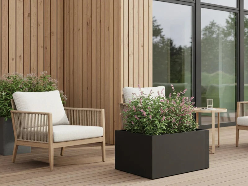 Lavt høybed i svart stål med blomstrende planter