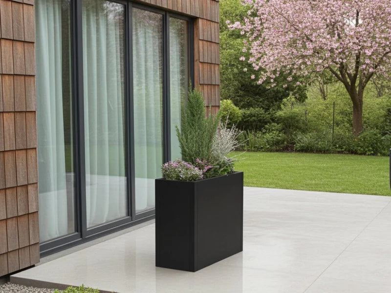 Minimalistisk plantekasse i svart stål ved moderne bolig