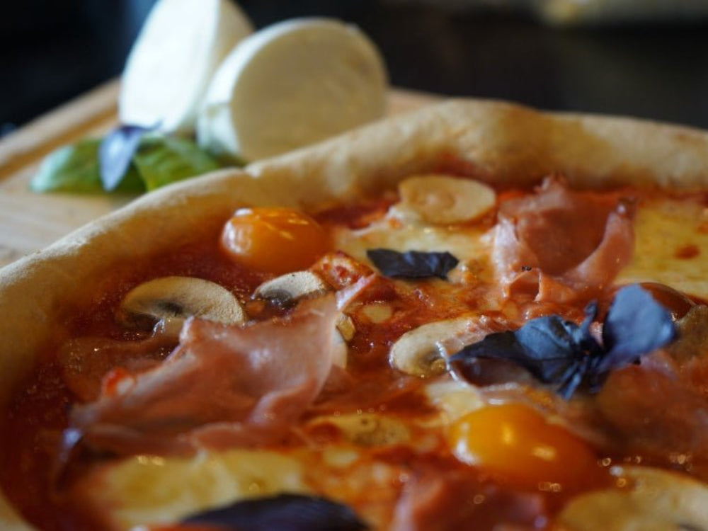 Hjemmelaget pizza med sprø bunn stekt ved høy varme