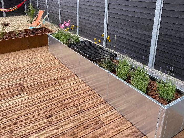 Lang plantekasse i galvanisert stål langs treterrasse