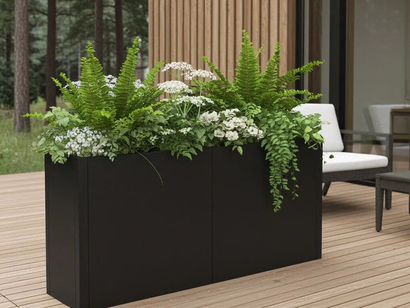 Plantekasse i svart stål med bregner og hvite blomster