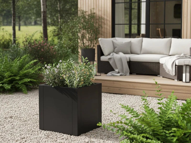 Plantekasse i svart stål med grønn beplantning ved terrasse