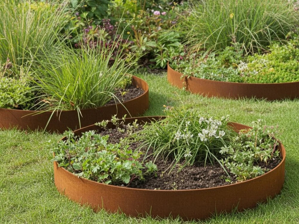 Runde bedkanter i cortenstål med stauder og prydgress i hageplen