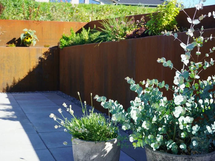 Støttemur i cortenstål rundt plantebed ved terrasse