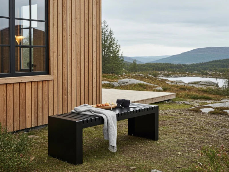 U-benk i sort stål ved nordisk trehus