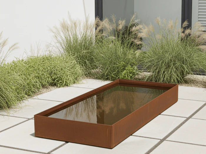 Rektangulaert vannkar i cortenstal som moderne vannspeil i hage