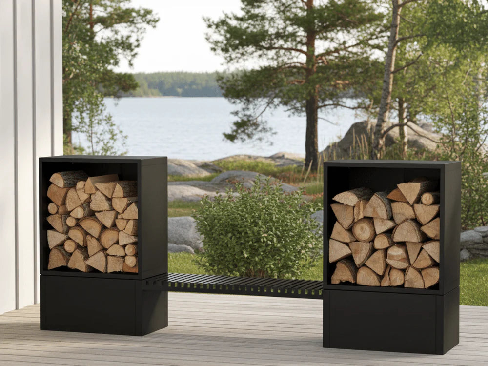 Vedoppbevaring i sort pulverlakkert stål med integrert sitteforbindelse på terrasse med sjøutsikt