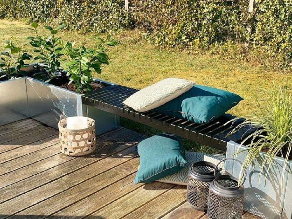 Vinkel plantekasse i galvanisert stål med svart benk på treterrasse