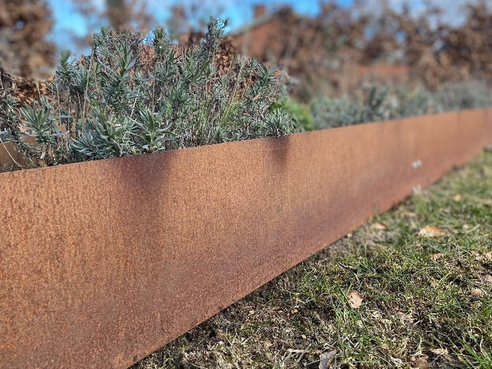 Lang bedkant i cortenstål på spesialmål fra byJEMA som avgrensning rundt plantebed i hagen