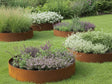 Runde bedringe i cortenstål med blomster og planter på gressplen