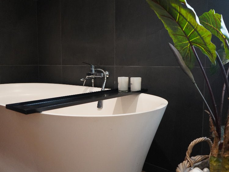 Badekarhylle i sortlakkert stål plassert over frittstående badekar