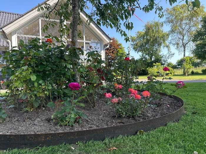 Rund bedkant i cortenstål fra byJEMA på spesialmål med lavendel rundt flaggstang