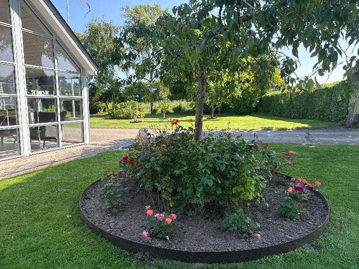 Stor rund bedkant i cortenstål fra byJEMA på spesialmål rundt rosebed