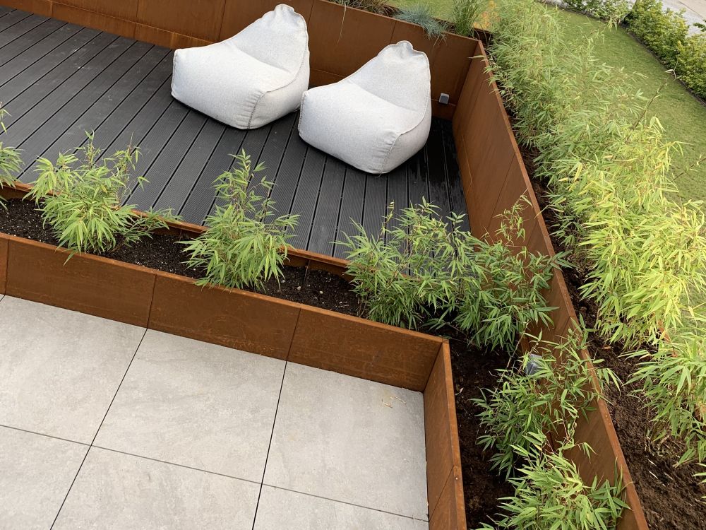 byJEMA plantekasser i cortenstål integrert i terrasse med sitteområde