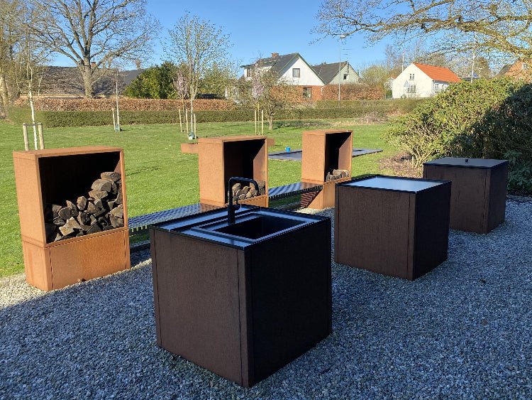 Utekjøkken i cortenstål med integrert vedoppbevaring og sittebenk