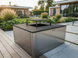 CUBY bålgrill i galvanisert stål i stilren designhage med terrasse