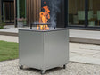 CUBY bålgrill i galvanisert stål på terrasse ved hus med planter og synlige flammer