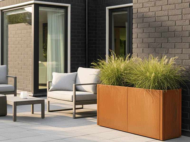 CUBY plantekasse i cortenstål med prydgress ved sitteplass
