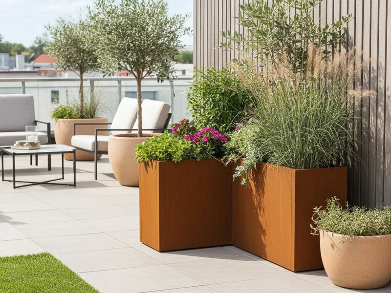 Vinkelplantekasse i cortenstål fra CUBY med blomster på terrasse