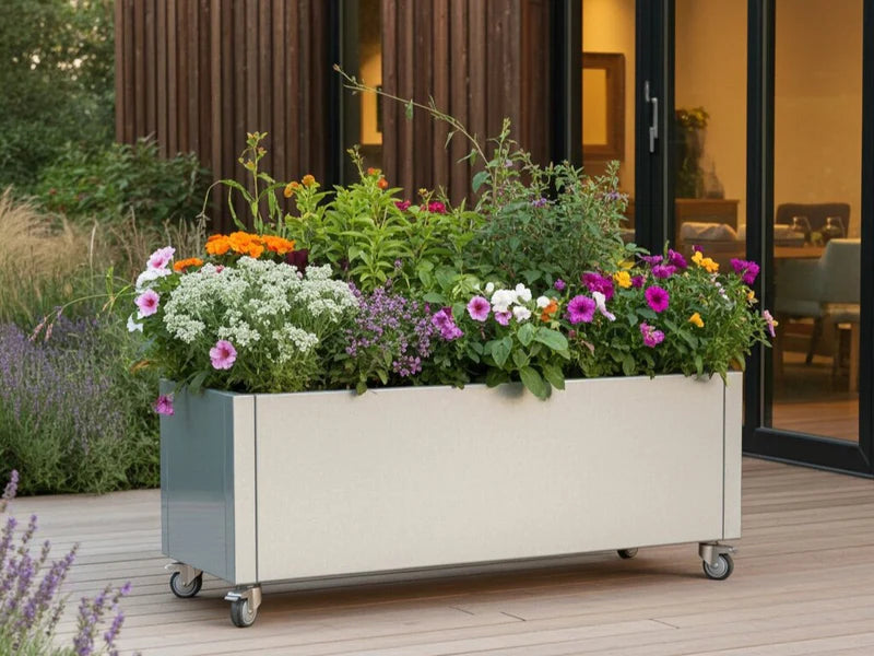 Plantekasse i galvanisert stål fra CUBY på hjul med blomster