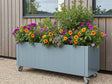 Plantekasse i galvanisert stål fra CUBY på hjul med blomstrende planter