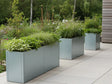 Plantekasser i galvanisert stål fra CUBY med stauder langs terrasse