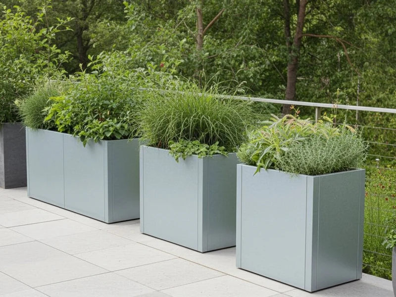 Flere plantekasser i galvanisert stål fra CUBY med prydgress
