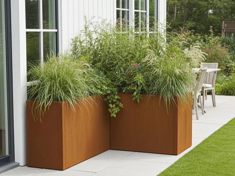 Plantekasse i cortenstål fra CUBY brukt som hjørnebed ved fasade