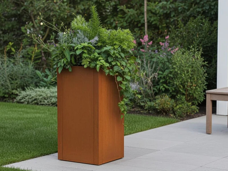 Høy CUBY plantekasse i cortenstål med planter i hage