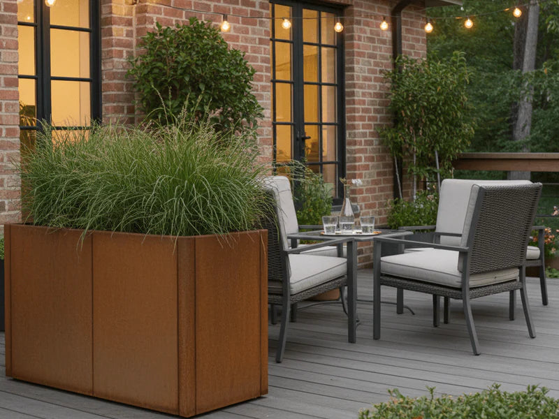 Stor plantekasse i cortenstål fra CUBY ved sittegruppe på terrasse