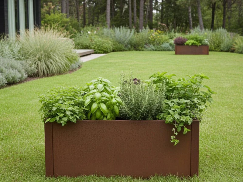 Rektangulær plantekasse i cortenstål fra CUBY med urter på gressplen