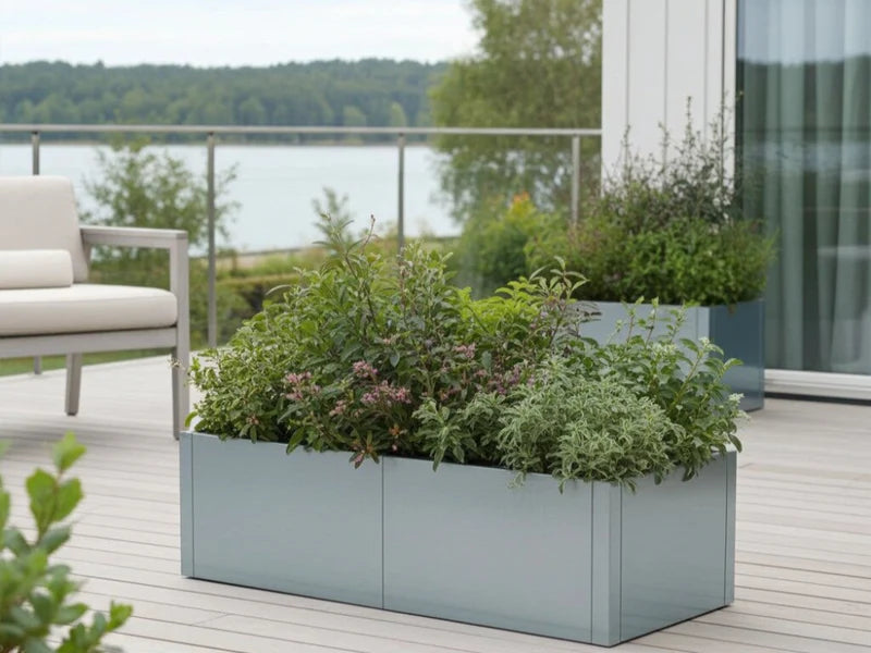 CUBY lav plantekasse i galvanisert stål med grønne planter på terrasse med utsikt