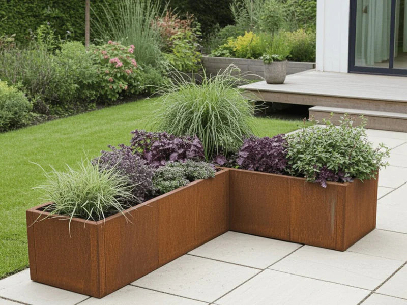 CUBY vinkel plantekasse i cortenstål med prydgress og stauder på terrasse