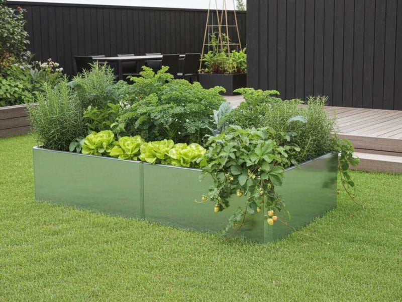 EDGY høybed i galvanisert stål med frodig beplantning ved mørk vegg