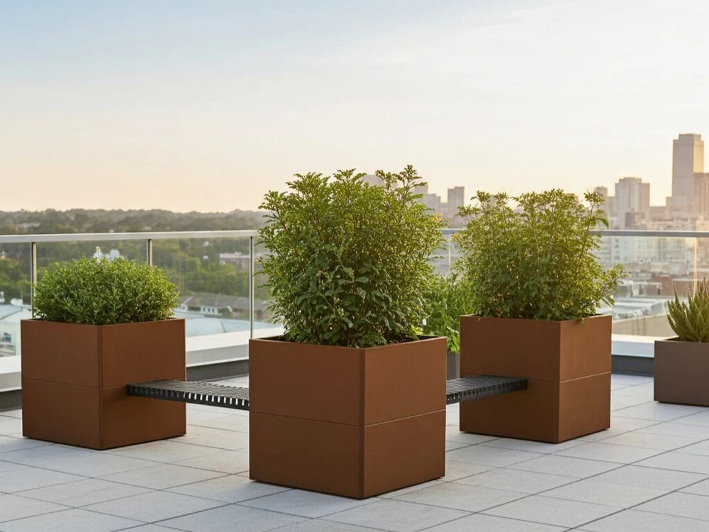 EDGY plantekasser i cortenstål med sort benk i urbant miljø
