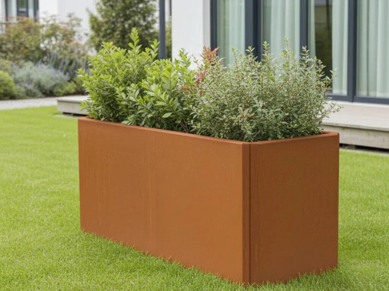 Rektangulær EDGY plantekasse i cortenstål med grønn beplantning i hage