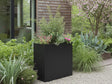 Plantekasse i svart stål med grønn beplantning i hage
